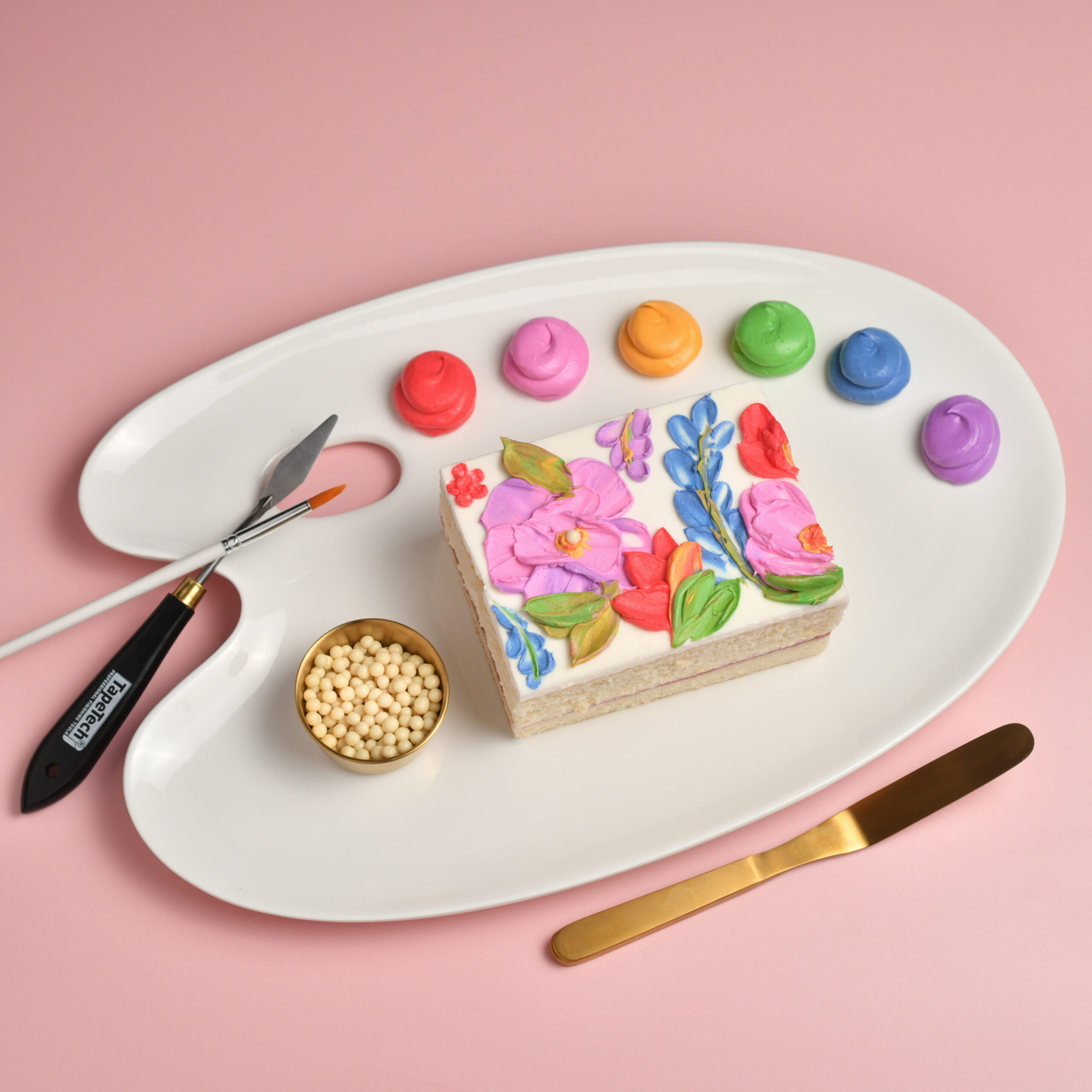 Cakeistry cake decorating experience at The Glass Knife in Winter Park with personal cake, colorful buttercream, and palette knives.