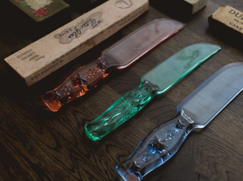 Vintage Depression-era pressed glass cake knives in pink, green and cobalt
