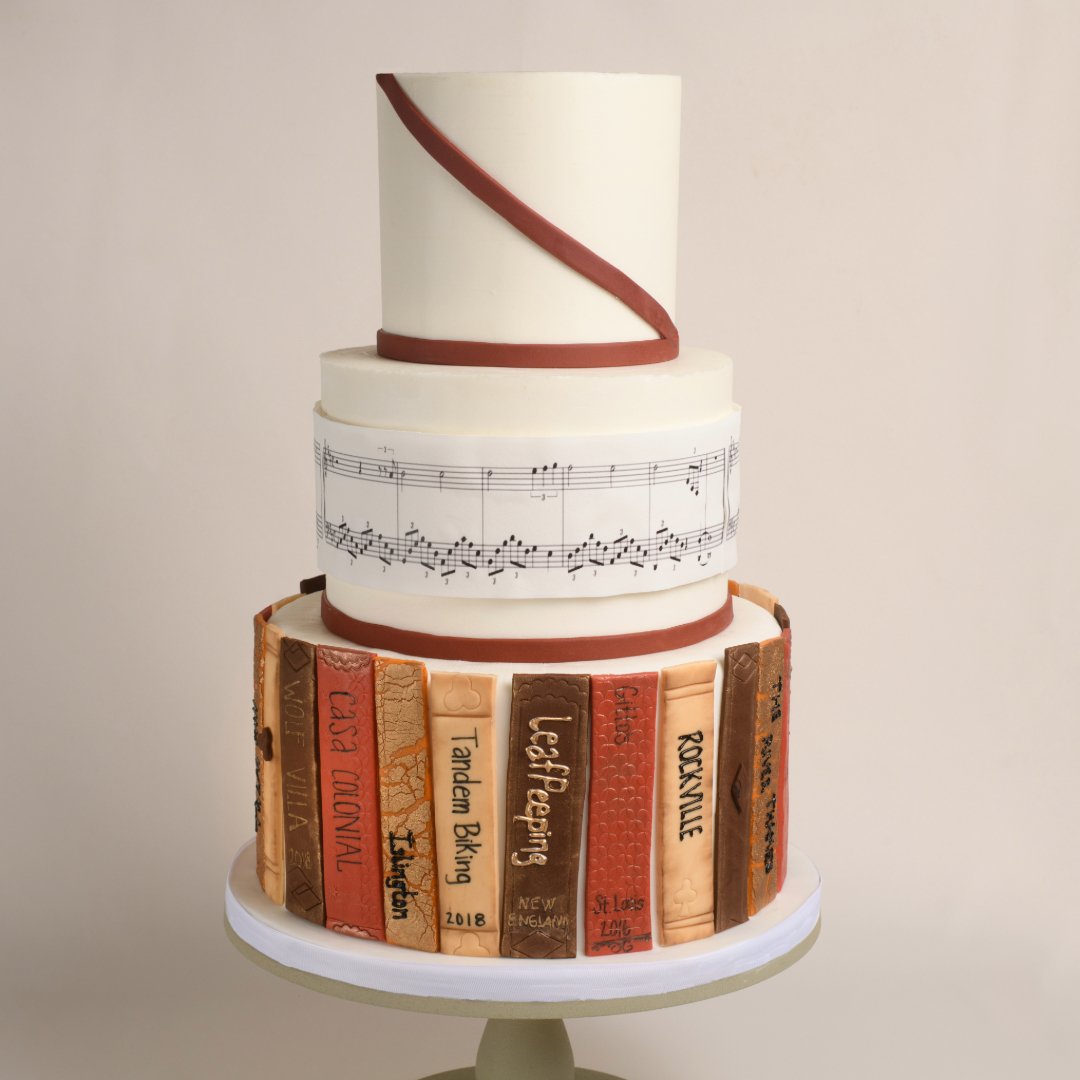 Unique custom three tiered wedding cake with a library and music theme.